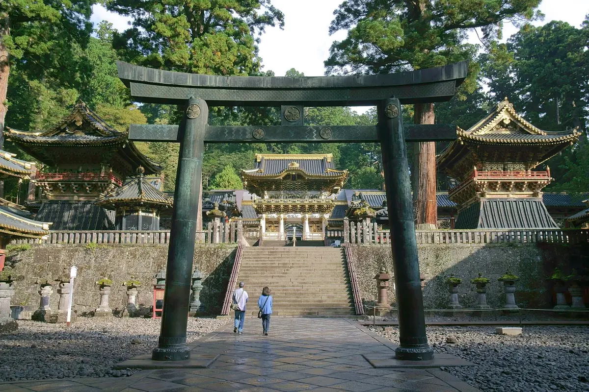 A stone torii and shrine buildings at Nikko Toshogu